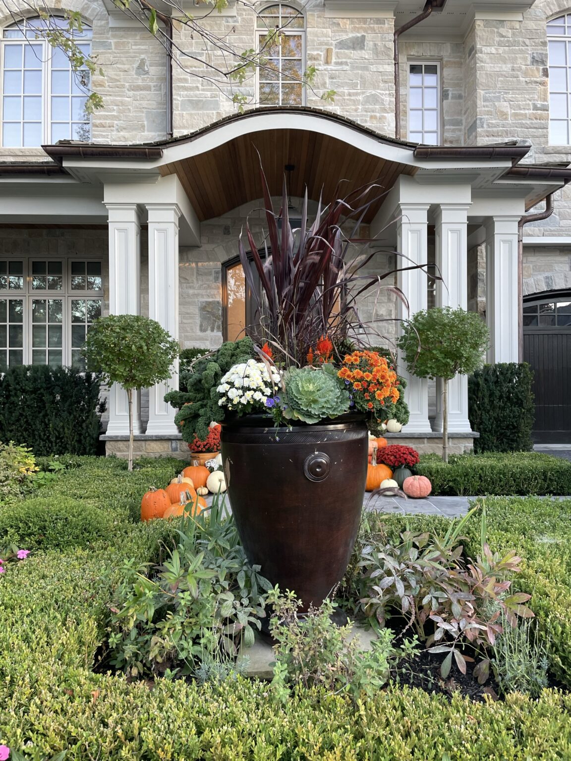 Vanessa’s autumn planter with burgundy grasses, ornamental kale and chrysanthemums in a bronze urn