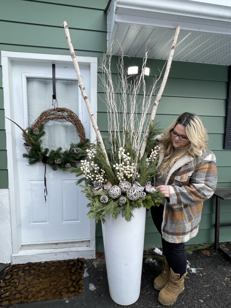 Vanessa Monardo adding the finishing touches to a winter planter